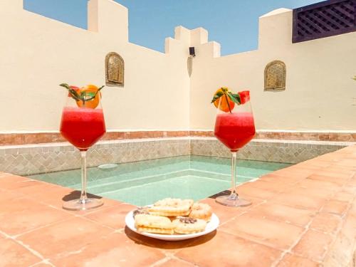 a table with three cocktails and a plate of food at Riad des Lys in Marrakesh