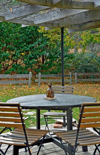 a teddy bear sitting on a table under an umbrella at Malia - Chambres d'hôtes & Gîte in Barret-de-Lioure