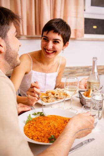 a man and woman sitting at a table with a plate of food at New Bristol Sport Hotel in Cesenatico
