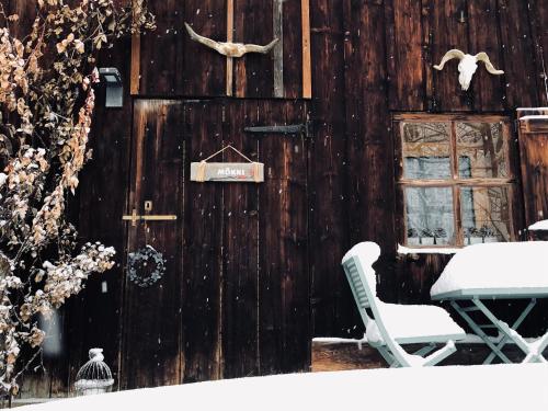 - un bâtiment en bois avec une table et une chaise dans l'établissement Le Pika, à Hauteluce