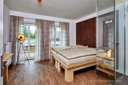 a bedroom with a bed and a glass shower at Hotel aanders in Neumünster