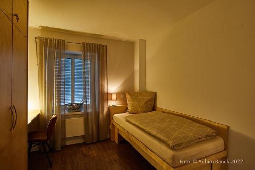 a small bedroom with a bed and a window at Hotel aanders in Neumünster