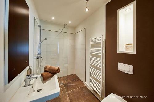 a bathroom with a sink and a glass shower at Hotel aanders in Neumünster