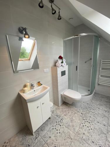 a bathroom with a toilet and a sink and a shower at Azymut in Suwałki