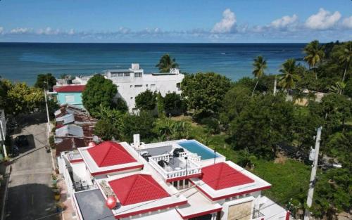 una vista aérea de una casa con techos rojos y el océano en Villa colonial suite n 4 basic interior en Río San Juan