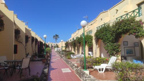 an empty street with tables and chairs and buildings at Castillo Mar 95 in Caleta De Fuste