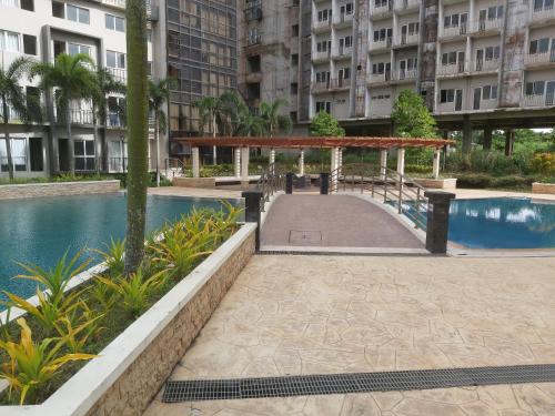 a walkway next to a pool in a building at Affordable Tagaytay Monteluce 1BR with Pool G10 in Lalaan Primero