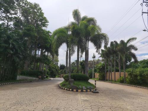 a street with palm trees on the side of a road at Affordable Tagaytay Monteluce 1BR with Pool G10 in Lalaan Primero