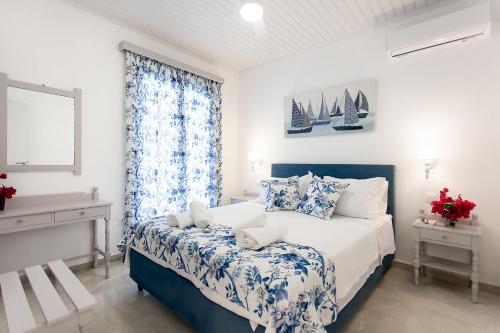 a bedroom with a blue and white bed and a window at oliva e mare luxury suite in Corfu Town