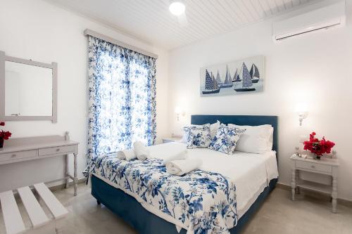 a bedroom with a blue and white bed and a window at oliva e mare luxury suite in Corfu