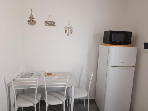 een kleine witte tafel met stoelen en een magnetron bij Appartamenti Mamma Marisa in Minturno