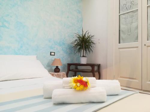 a bedroom with a bed with towels and a flower on top at Dimora Maltese in Morciano di Leuca