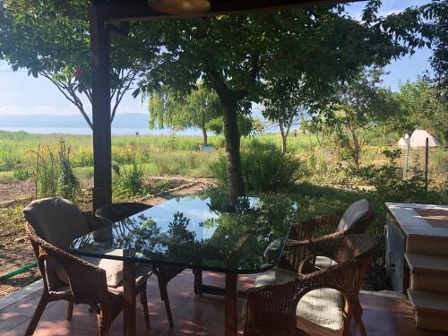 a glass table and chairs on a patio with a view at Home on Iznik Lake with its own Private Beach in Bursa