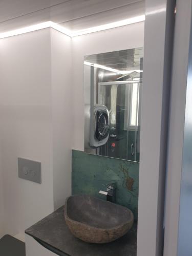 une salle de bain avec un lavabo en pierre et un miroir dans l'établissement Le Miroir, au Cap d'Agde