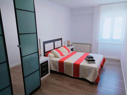 Dormitorio pequeño con cama y espejo en Apartamento El Torreón, con opción a parking, en Zaragoza