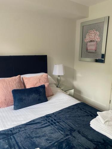 a bedroom with a bed with pink and blue pillows at The Bay house Apartments , shanklin in Shanklin