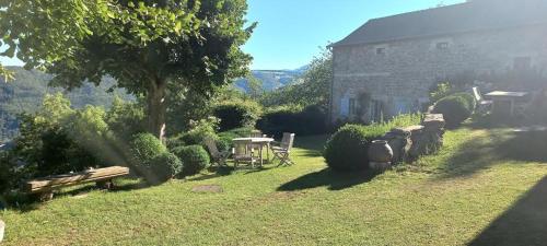 a garden with a table and a tree and a building at Bérard in Intres