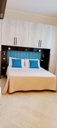 ein Schlafzimmer mit einem großen Bett mit blauen und weißen Kissen in der Unterkunft Villa Ginevra in Porto Cesareo