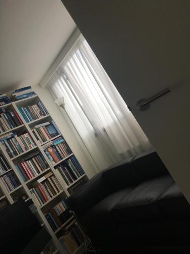 a room with a book shelf filled with books and a window at Retour de Provence in Almelo