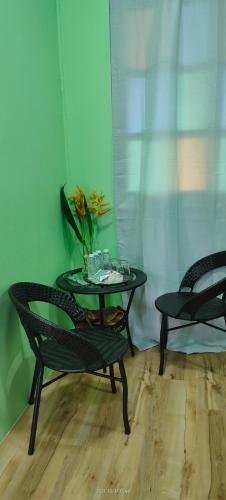 a table and two chairs and a table with a vase on it at Bungalow Mat Hj Limah in Alor Setar