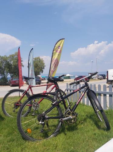 two bikes parked in the grass next to windsurfs at Ammos Hotel in Agia Triada