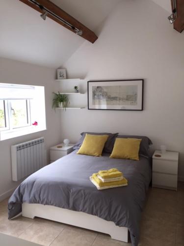 a bedroom with a bed with two yellow pillows at The Cottage at No. 3 in West Lavington