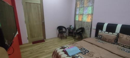 a bedroom with a bed and a table and chairs at Bungalow Mat Hj Limah in Alor Setar