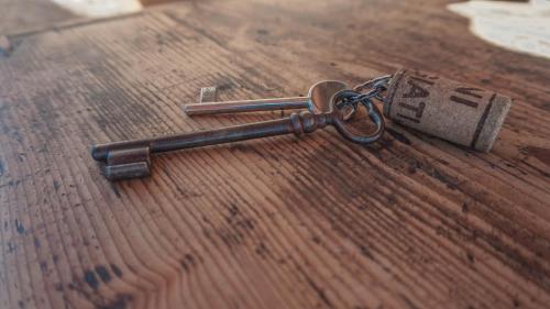 a key on top of a wooden table at B&B La Buonora in Sinio