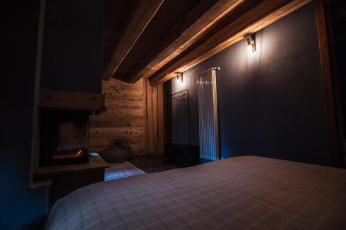 a bedroom with a bed and a fireplace at B&B Ca' Mea room, wellness & food in Levata