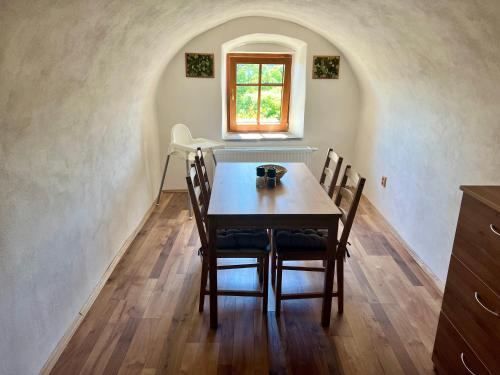 a table and chairs in a room with a window at EDER- Penzion & Apartmány in Horní Planá