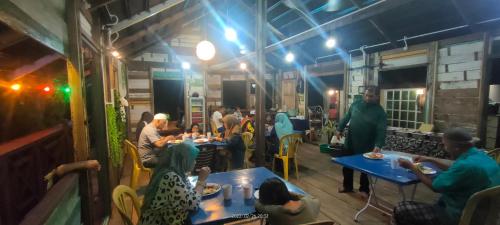 a group of people sitting at tables in a restaurant at Bungalow Mat Hj Limah in Alor Setar