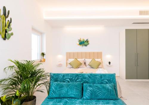 a living room with a blue couch in front of a bed at Coppa Carrubo Residenza in Vieste
