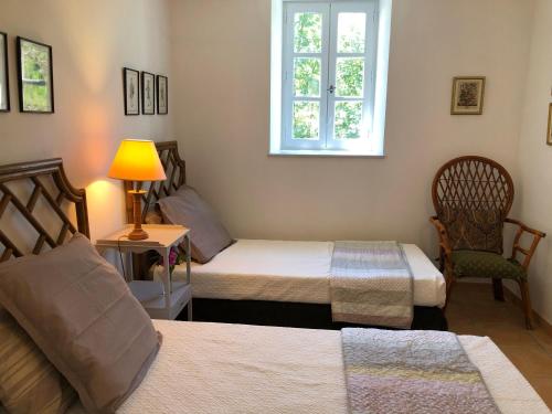 Habitación con 2 camas, silla y ventana en Lovely 2 bedroom gite with shared pool, en Castres