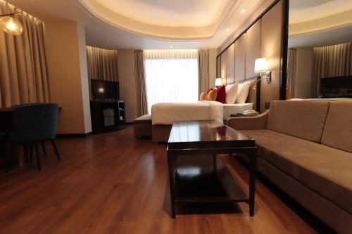 a living room with a couch and a table at The Vaishnodevi Sarovar Portico in Katra