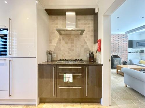 een keuken met een spoelbak en een fornuis bij Clyde Villa in Glasgow