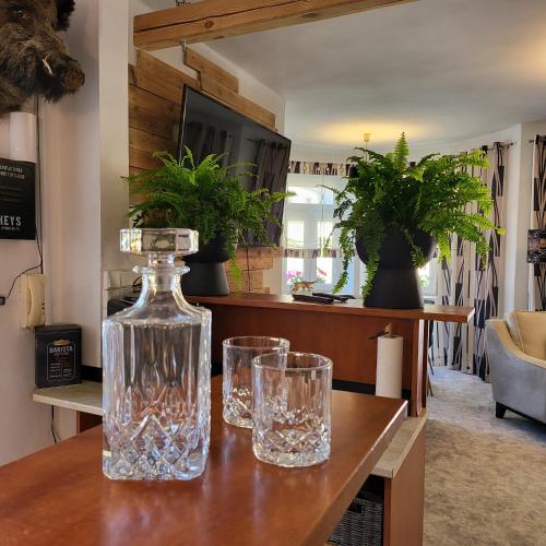 two glasses and a bottle on a table at Apartment Villa Hřensko 132 in Hřensko