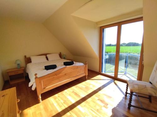 um quarto com uma cama e uma grande janela em Maison familiale jardin à 700m des plages Ty Nowen em Trégunc