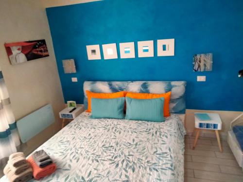 a bedroom with blue walls and a bed with orange pillows at Il Rifugio dei Colonna casadolcecasa in Marino