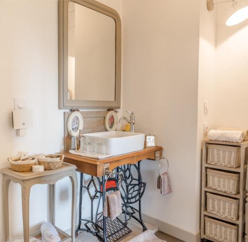 uma casa de banho com um lavatório e um espelho em Au Clair de Vianne em Vianne