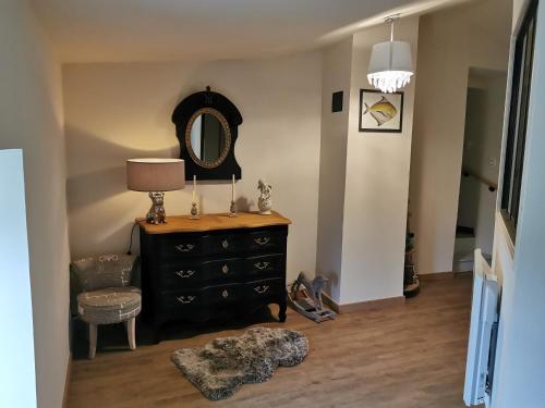 a room with a dresser with a mirror and a lamp at Au domaine de Gigie in Chervettes