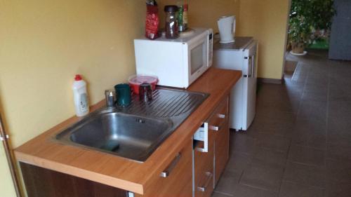 a kitchen with a sink and a microwave at Pokoje w Uzdrowisku in Przerzeczyn-Zdrój