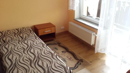 a bedroom with a bed and a window and a rug at Pokoje w Uzdrowisku in Przerzeczyn-Zdrój