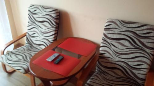 a table with a remote control on it next to a bed at Pokoje w Uzdrowisku in Przerzeczyn-Zdrój