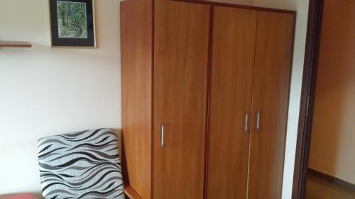 a wooden cabinet in a room with a zebra chair at Pokoje w Uzdrowisku in Przerzeczyn-Zdrój