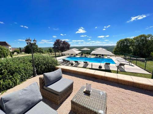 une terrasse avec une piscine, des chaises et une table dans l'établissement Hôtel Les Vieilles Tours Rocamadour, à Rocamadour