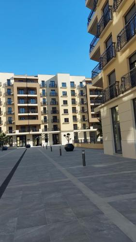 a large courtyard in front of a large building at Green Hills by Rent a car MI in Podgorica