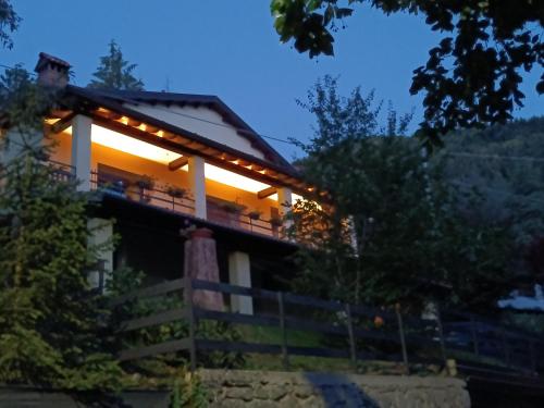 a house with lights on the balcony at night at B&B Il Ghiro in Riolunato