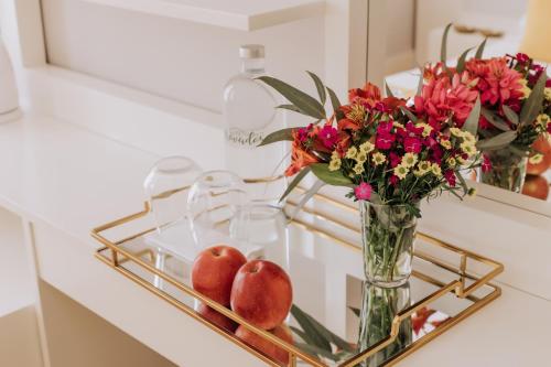 a glass vase filled with flowers on top of a counter top at Trovador City Guest House in Guimarães