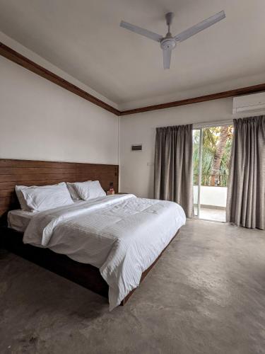 a bedroom with a large bed and a large window at Dhoadhi Retreat in Thulusdhoo