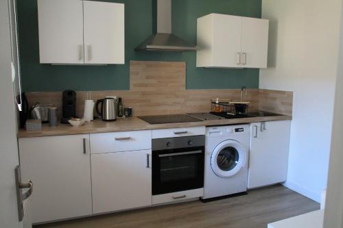 a kitchen with white cabinets and a washing machine at Besançon appartement T2 sur cour intérieure proximité gare in Besançon